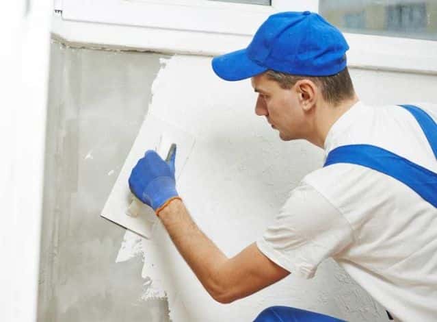 Plasterer finishing a wall